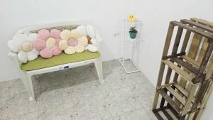 a white chair with a bunch of stuffed flowers on it at Duck and Drift Hostel - A sleeper Hostel in Puerto Princesa City