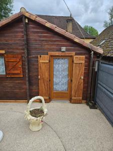 ein Gebäude mit einer Tür und einem Korb davor in der Unterkunft Le petit chalet in Gigouzac