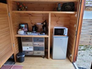 eine kleine Küche mit Kühlschrank und Mikrowelle in der Unterkunft Le petit chalet in Gigouzac