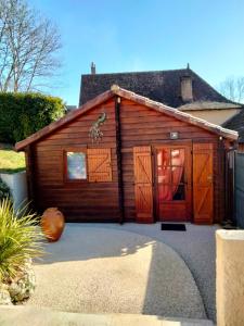 eine Holzgarage mit einem Kürbis davor in der Unterkunft Le petit chalet in Gigouzac