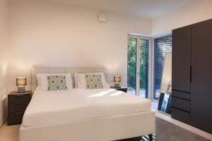 een slaapkamer met een groot wit bed en een raam bij Villa Casaliva with Private Pool in Albisano +54 foto's