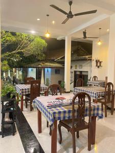 a restaurant with tables and chairs and a ceiling fan at Susee Villa in Bentota