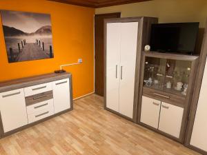 Zimmer mit einem TV und einem weißen Schrank in der Unterkunft Ferienhaus Riegler in Trattenbach + 6 Fotos