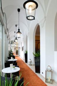 un pasillo con mesas y macetas en un edificio en Hotel Sacher Baden, en Baden