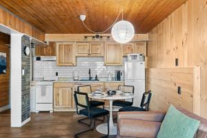 eine Küche mit Holzschränken und einem Tisch und Stühlen in der Unterkunft Ski In Ski Out Hunter Mtn Seasonal Pool Access w Panoramic Views Hike Swim Fish Unwind in Lanesville