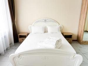 Bekarys Hotel في أستانا: سرير أبيض عليه أغطية ووسائد بيضاء