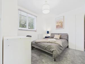 a white bedroom with a bed and a window at Green Hat Stays Newport City in Newport