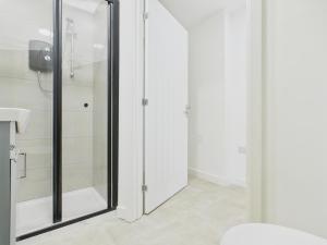 a bathroom with a glass shower and a toilet at Green Hat Stays Newport City in Newport