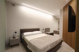a bedroom with a bed and a flat screen tv at Casetta Miranda in Naples