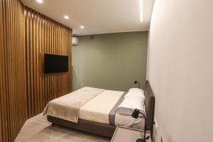 a bedroom with a bed and a flat screen tv at Casetta Miranda in Naples