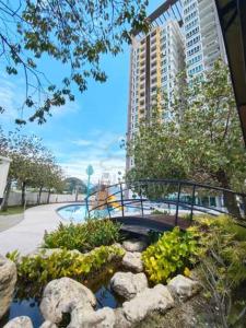 怡保Ipoh D Festivo Suites 6-10pax 10mins to Sunway Tambun by IWH的城市中一座花园，花园里有一座桥横跨池塘。