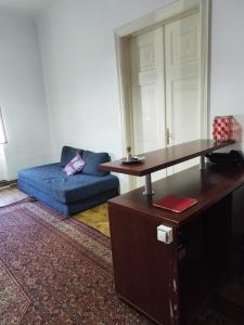 een woonkamer met een blauwe bank en een tafel bij Hostel Latin Bridge in Sarajevo +7 foto's