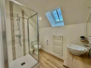 une salle de bain avec une douche en verre et un lavabo dans l'établissement Maison de vacances Le Raboliot proche de Chambord, à Montlivault