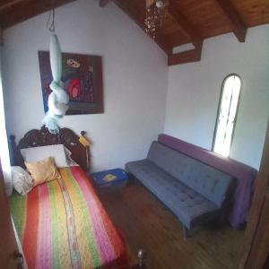 a bedroom with a bed and a bench in it at El ceibo in Agua de Oro