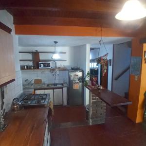 a kitchen with a stove and a refrigerator at El ceibo in Agua de Oro
