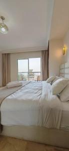アガディールにあるmarina1の窓のある部屋にある大きな白いベッド
