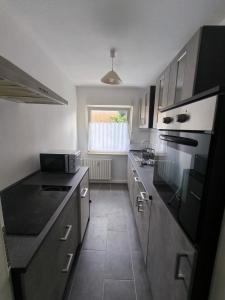 een keuken met een spoelbak en een fornuis bovenste oven bij Mego Unterkünfte 3 in Bönen