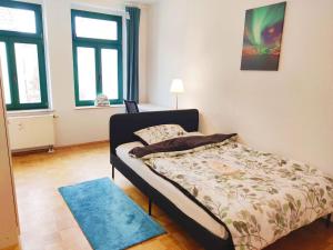 a bedroom with a bed and a blue rug at Lebensfreude in Markkleeberg