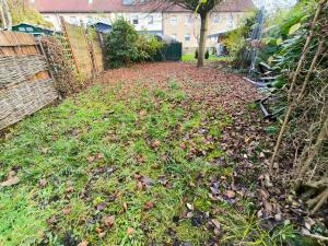 een tuin met bladeren op het gras en een hek bij Mego Unterkünfte 3 in Bönen +5 foto's