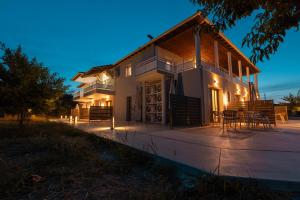 a house with a table and chairs on a patio at Thrive in Sarti