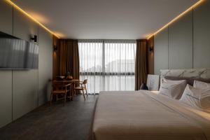 een hotelkamer met een bed en een tafel met stoelen bij Awwa Boutique Hotel in Canggu +30 foto's