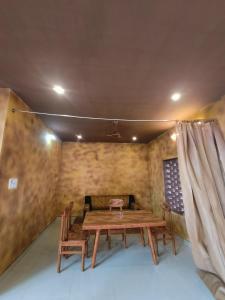 un tavolo e sedie in legno in una stanza con soffitto di Sp Queens Garden a Madurai