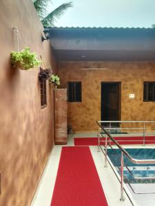 un corridoio con un tappeto rosso e una piscina di Sp Queens Garden a Madurai