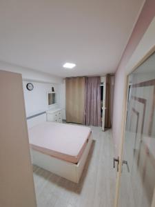 een slaapkamer met een wit bed in een kamer bij Fiald Apartamente New in Bacău