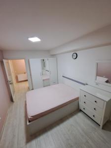 een slaapkamer met een bed, een ladekast en een spiegel bij Fiald Apartamente New in Bacău