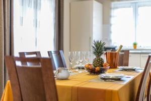 a dining room table with a pineapple and wine glasses at Flores Luxury Suites-Rogoznica in Rogoznica