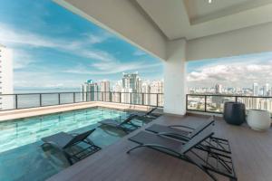 Una piscina con sillas y vista a la ciudad. en Sunny Studio for Rent w Park Views in Panama City, en Panamá 15 fotos más