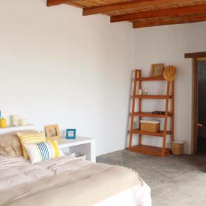 una camera con letto e mensola in legno di Puemape Surf Camp a Puémape