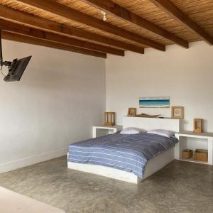 una camera da letto con un letto in una stanza bianca di Puemape Surf Camp a Puémape