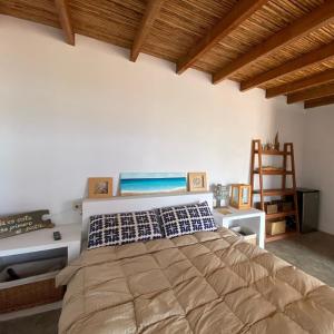 una camera da letto con un letto grande e un soffitto in legno di Puemape Surf Camp a Puémape