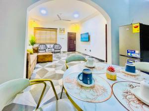 a living room with a table and chairs at Caro Spacious Apartment for leisure stay in Accra