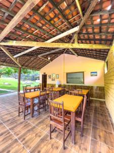 ボニートにあるSítio Piscina do Violãoの木製のテーブルと椅子、スクリーンが備わるレストラン +75枚の写真