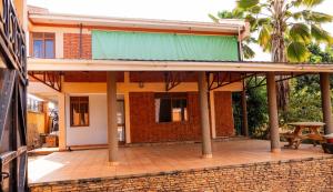 a house with a green roof and a patio at Muyenga guestroom in Kampala