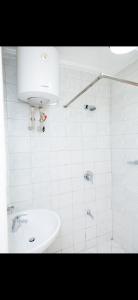 a white bathroom with a sink and a shower at Muyenga guestroom in Kampala