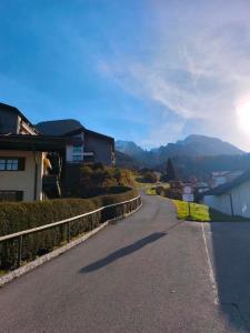een lege weg met een huis en bergen op de achtergrond bij Ferienwohnung Watzmann Nesterl in Berchtesgaden +7 foto's