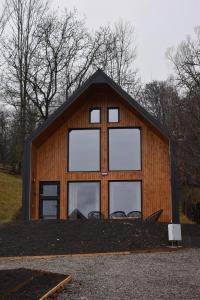 ein Gebäude mit vier Fenstern an der Seite in der Unterkunft Kolibe Doftana in Trăisteni