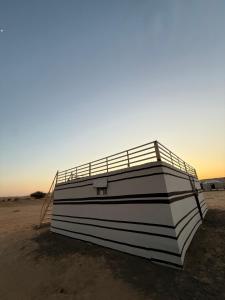 a boat sitting on the beach at sunset at Hawyan Camp in Badīyah