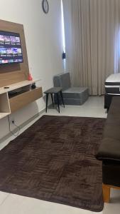 a living room with a couch and a flat screen tv at Kitnet Muriqui 2 in Mangaratiba +10 photos