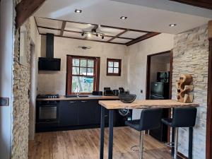 une cuisine avec des placards bleus et un mur en pierre dans l'établissement Le rêve au fil de l'eau, à Marmagne