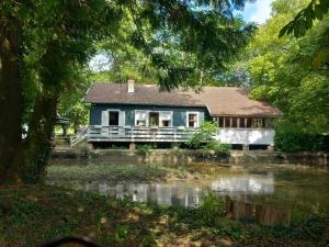 une maison avec une rivière devant elle dans l'établissement Le rêve au fil de l'eau, à Marmagne