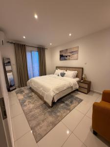 a bedroom with a large bed and a couch at East Legon Loxwood House Condo with Gym & Pool in Accra