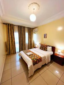 Ένα ή περισσότερα κρεβάτια σε δωμάτιο στο Appart'hôtel Micheline Suites, Bastos