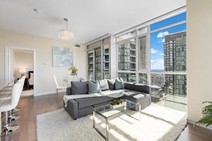 米西索加Ultra Luxurious 2.5 Bedroom 2 Full Bathroom 1 Parking Condo Near SQ1 Striking Views的客厅设有灰色的沙发和大窗户