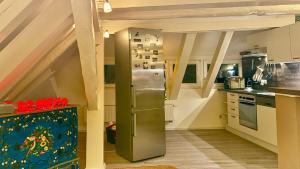 una cucina con frigorifero in acciaio inossidabile in mansarda di Kungs Ferienwohnung 2 a Cottbus