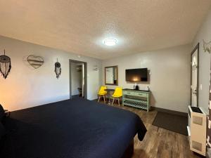 ein Schlafzimmer mit einem Bett und einem Schreibtisch mit zwei gelben Stühlen in der Unterkunft Lake Ridge South Lake Tahoe in South Lake Tahoe