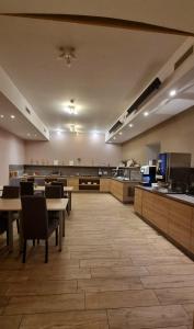 una cafetería con mesas y sillas y una cocina en Hotel Emonec, en Liubliana
